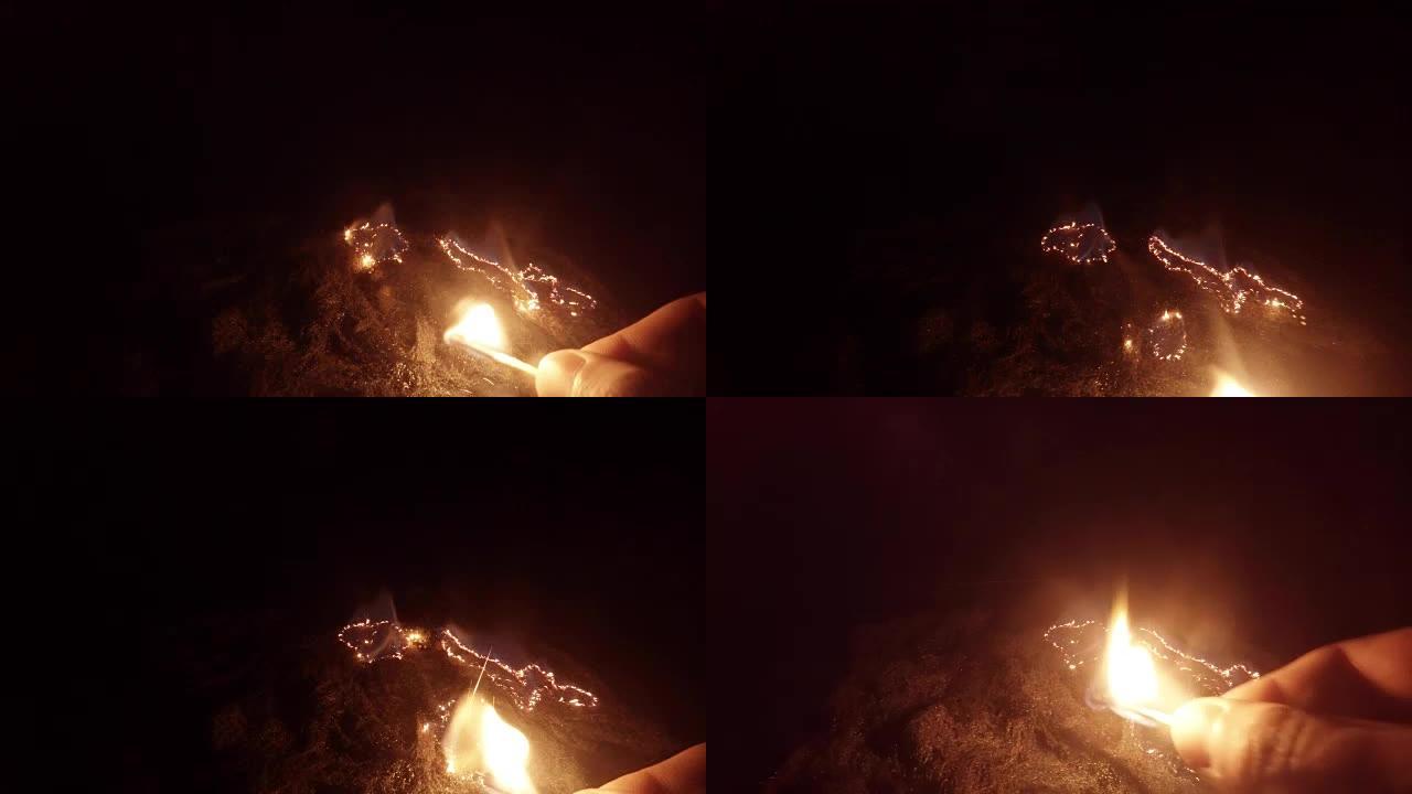 手指上的火柴在黑暗中的钢丝绒上创造了新的火焰口袋