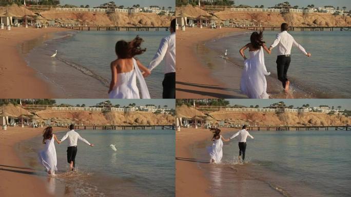 幸福的新婚夫妇在冲浪上奔跑。在埃及度蜜月。