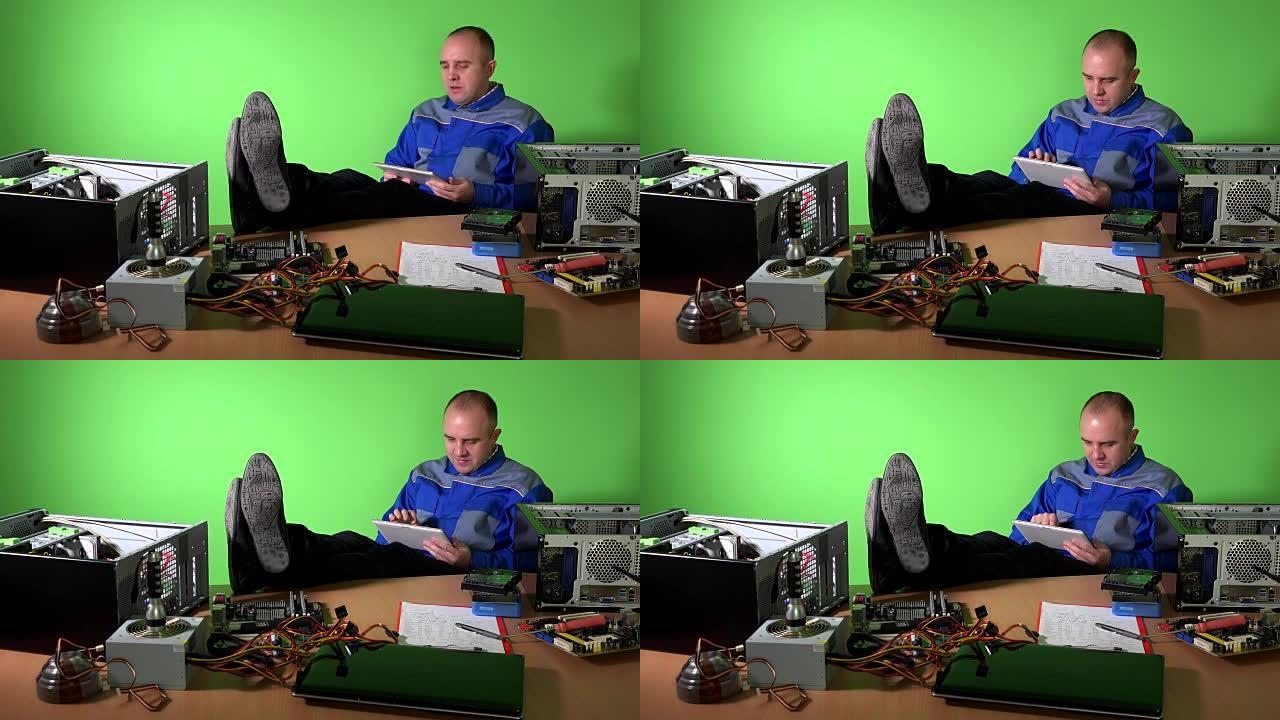 粗心的工程师，腿在桌子上玩平板电脑