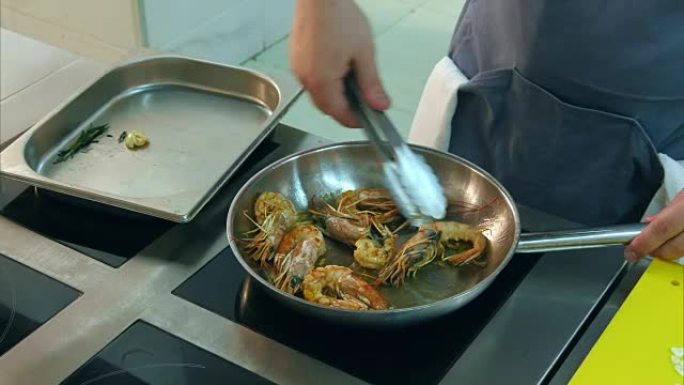 厨师在平底锅上油炸皇家虾并加入葵花籽油
