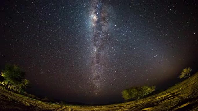 纳米比亚纳米布沙漠山脉外明亮的银河系和星空的明显旋转。鱼眼视图。延时视频。