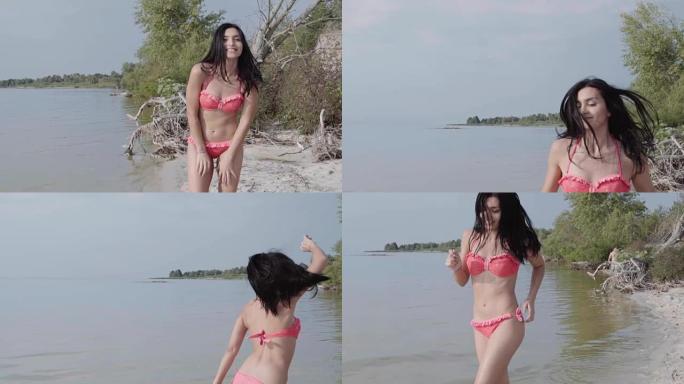 性感的西班牙裔黑发女郎穿着时髦的红色比基尼在海滩上奔跑，微笑着享受暑假