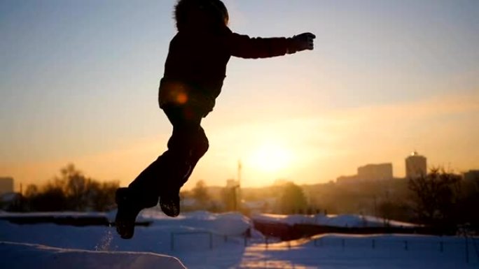 青少年在冬天在操场上玩耍。日落时在雪中翻转