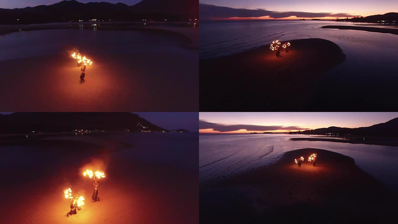 日落时在沙洲海滩上跳舞的火表演