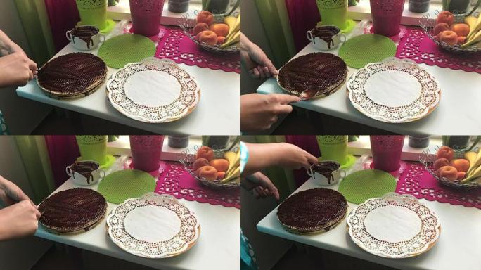 一个女人涂抹了巧克力薄饼。华夫饼蛋糕配煮炼乳和巧克力。烹饪过程。威化饼、可可和炼乳是烹饪的原料。