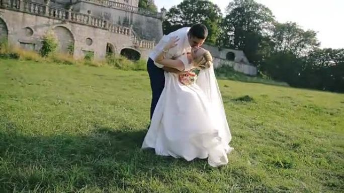 年轻的已婚夫妇在城堡附近接吻