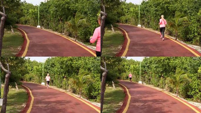 健身女性在夏季公园跑步。看着心率监测器，慢慢慢跑