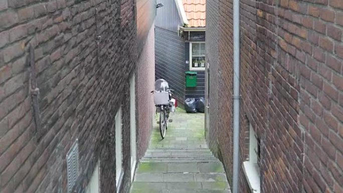 一辆小型摩托车停在建筑物的侧面