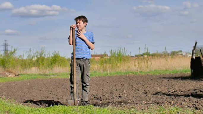 男孩农民疲倦地在干燥的地面上挖旧的脏铲慢动作视频