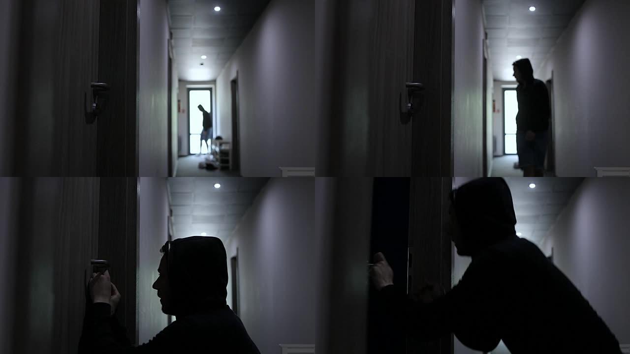 一名男子小偷在走廊上偷偷摸摸，打破了公寓的门