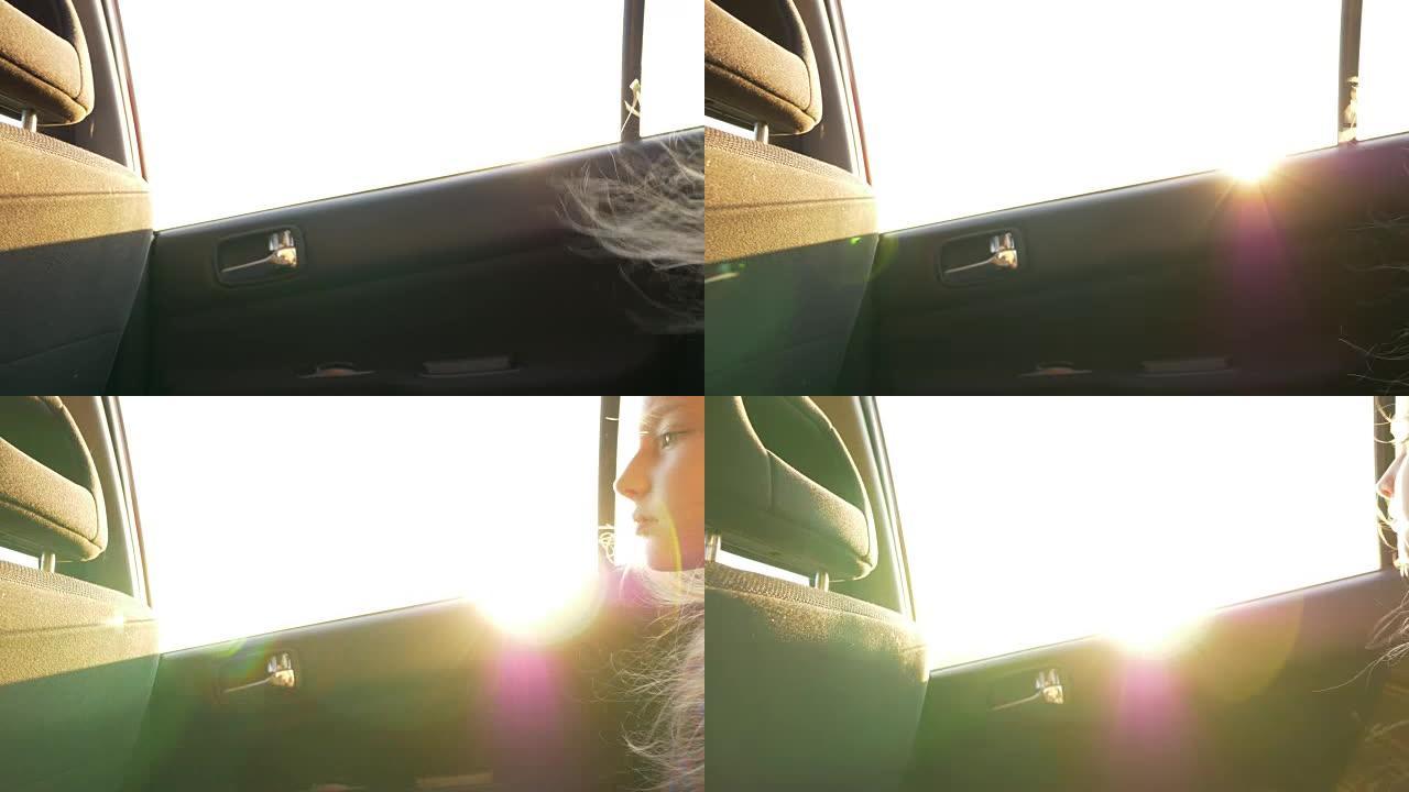 小女孩，无聊在车里。太阳耀斑。车窗上的日落灯。强风吹拂着头发。