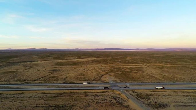 40号州际公路莫哈韦沙漠交通卡车行驶在高速公路上与贫瘠的景观，高速公路的每一边都有4k空中鸟眼稳定超