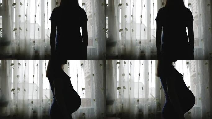 孕妇站在窗前。