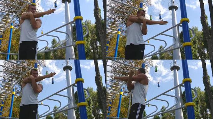 运动员在城市公园训练前热身身体和双手。年轻强壮的肌肉发达的人在运动场锻炼前会伸展身体。运动员在户外操