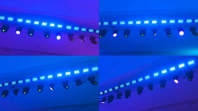 音乐会灯光设备在工作。专业照明投影仪自动旋转并闪烁不同颜色。光线来自光设备进入相机镜头