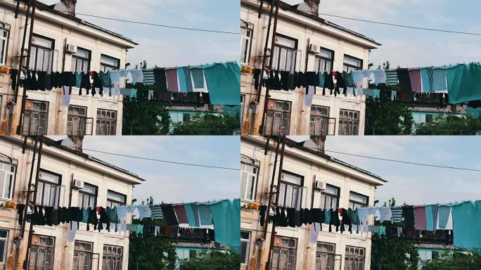 大量洗过的衣服挂在绳子上，在房子附近的街道上晾干