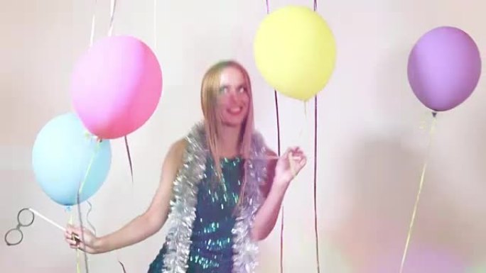 快乐的金发女人在照相亭里用气球跳跃