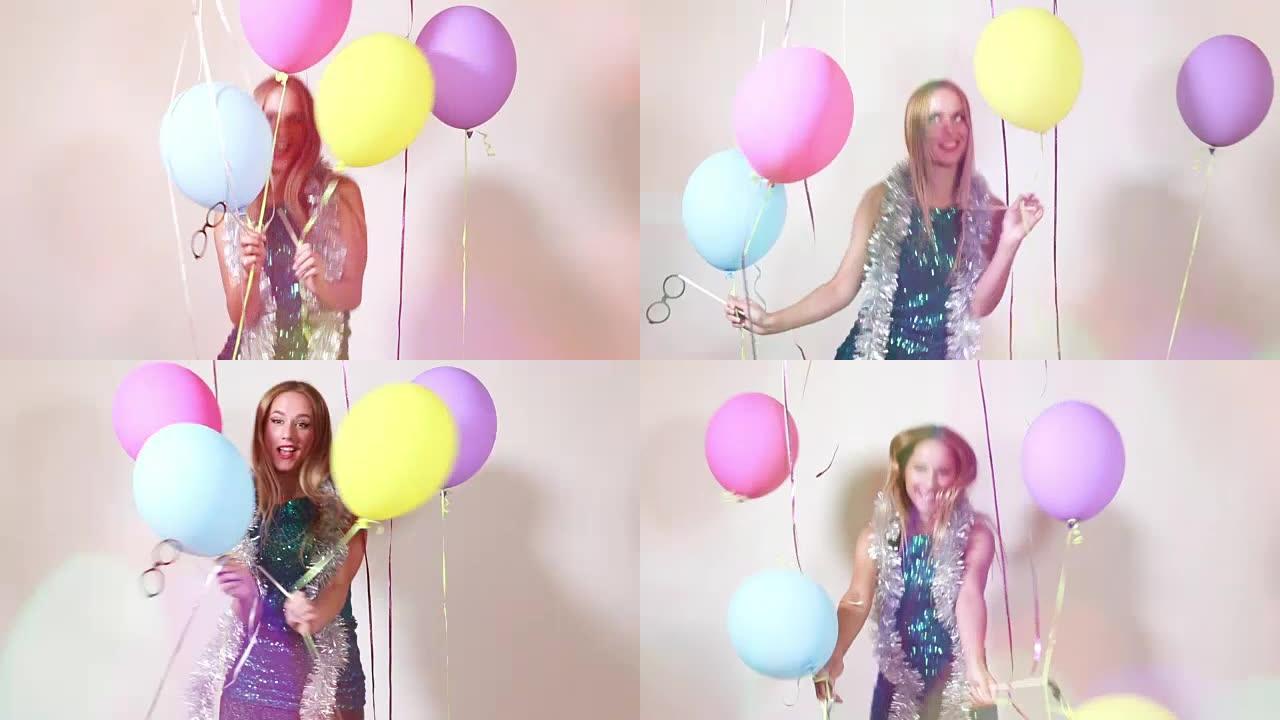 快乐的金发女人在照相亭里用气球跳跃
