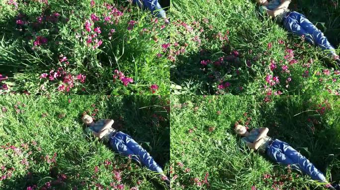 十几岁的男孩躺在草地上休息。