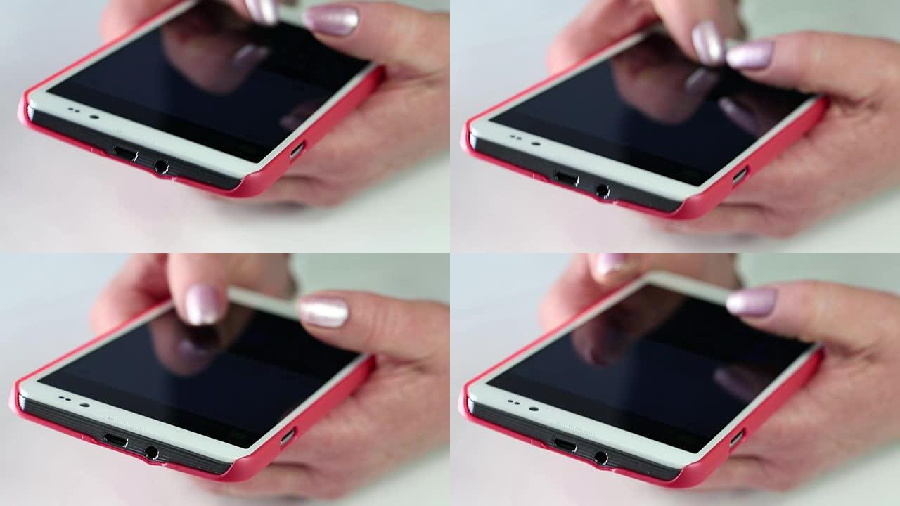 女人在手机上输入短信。用红色智能手机关闭女人的手