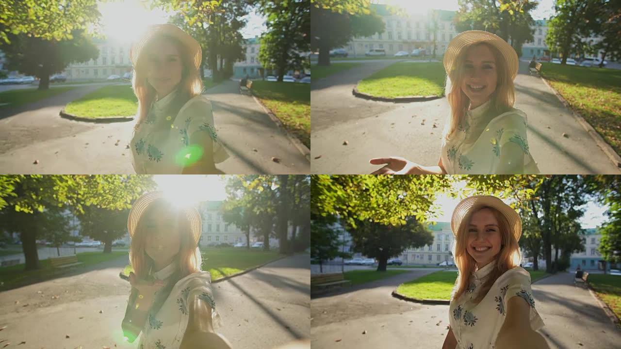 美丽女孩在日出时微笑的肖像。快乐的女孩用相机自拍。