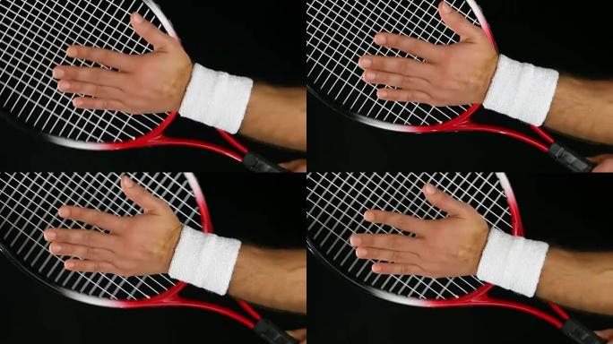 网球运动员的手打网球拍的慢动作，黑色背景
