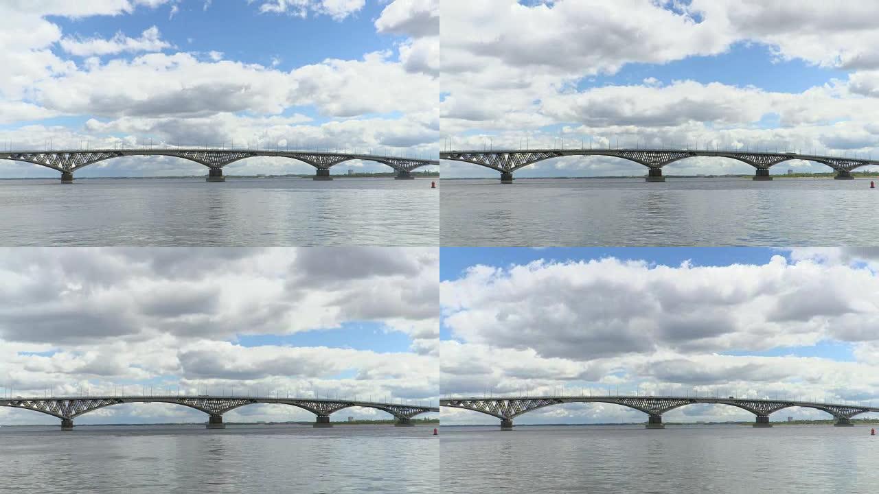 萨拉托夫市和恩格斯市之间横跨伏尔加河的公路桥。河流风景的时间流逝。漂浮在天空。桥上车辆的运动。夏日。