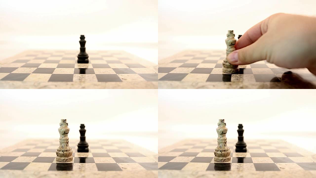 一个黑国王站在棋盘中间，一个人把一个白国王放在黑国王面前