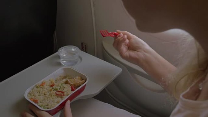 在飞机上吃饭的女人