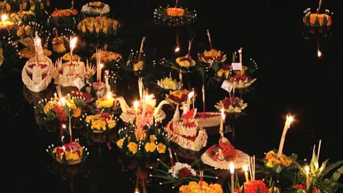 在Loi Khrathong庆祝活动中，燃烧的蜡烛漂浮在水面上。