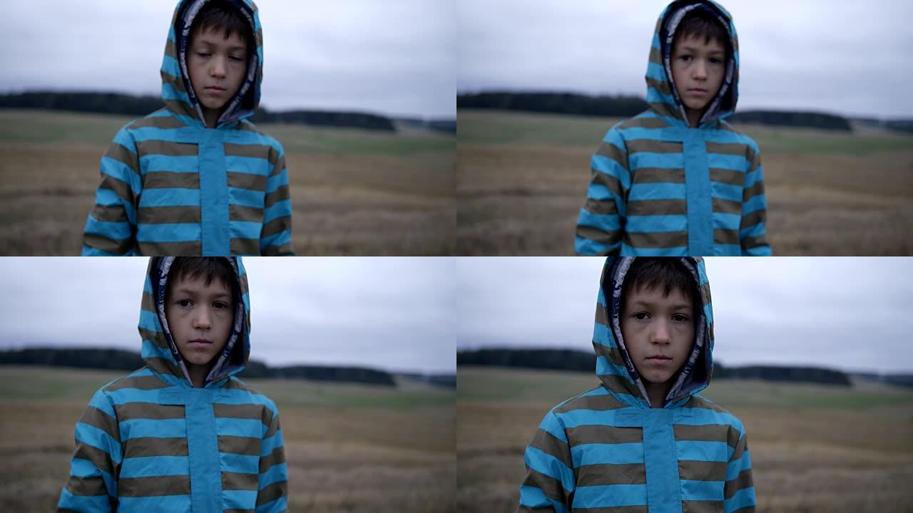 难民男孩同情地看着镜头，无家可归的男孩，脸上的疼痛