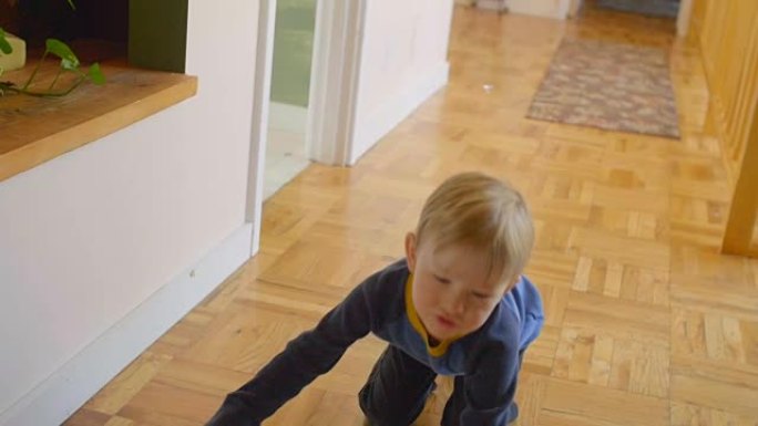 男孩在木地板上玩足球
