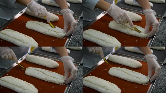 女人的糖果手穿着鲜艳的图案手套，在潮湿的测试中切开切口，很快就会变成美味的面包