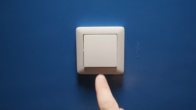 灯熄灭-人手关闭蓝色墙壁上的按钮