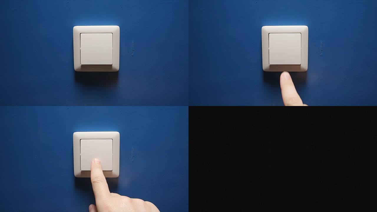 灯熄灭-人手关闭蓝色墙壁上的按钮