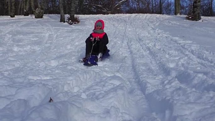 骑在雪橇上的女孩笑了。