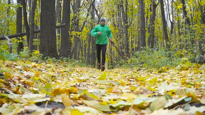 运动男子慢跑越野跑。在鼓舞人心的秋季景观中越野跑步时，在户外训练和锻炼。运动动机。慢动作。