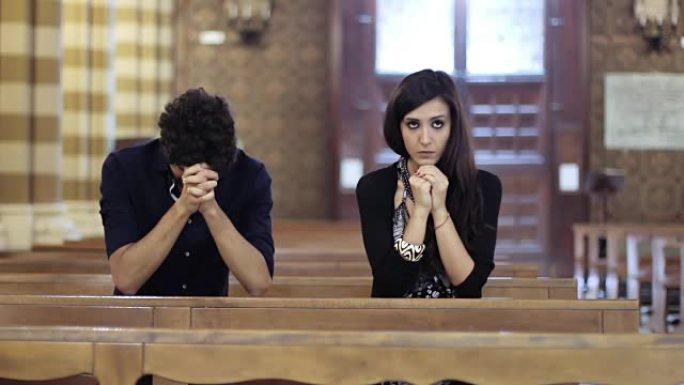 在教堂里祈祷的夫妇