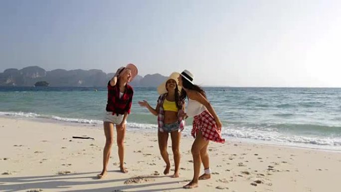 女人在海滩上从水上散步，年轻女孩的游客交流快乐的微笑