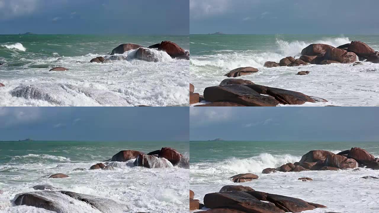 海浪在沿海粉色石头巨石上破碎。