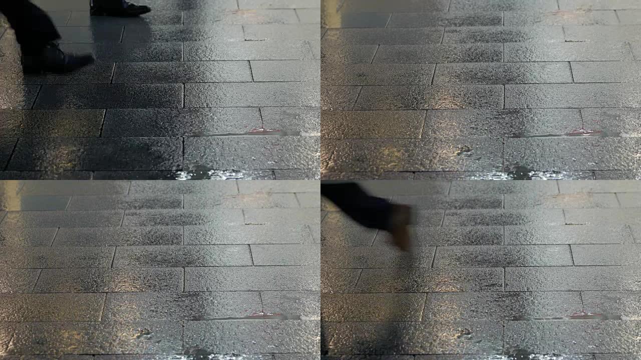 人行道上的雨滴和行人脚步声的慢动作视图。