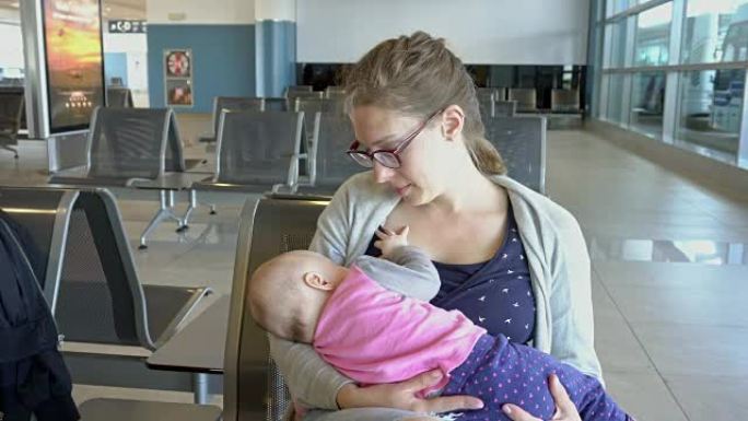 一名妇女在机场给孩子喂奶