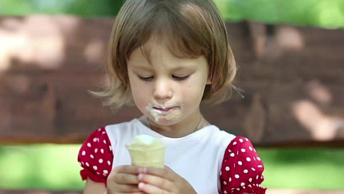小女孩坐在秋千上吃冰淇淋