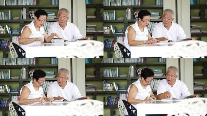 亚洲老年夫妇在小图书馆一起阅读书籍和杂志。学习和学习理念
