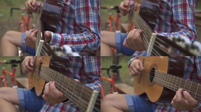男人弹吉他时坐在长凳上
