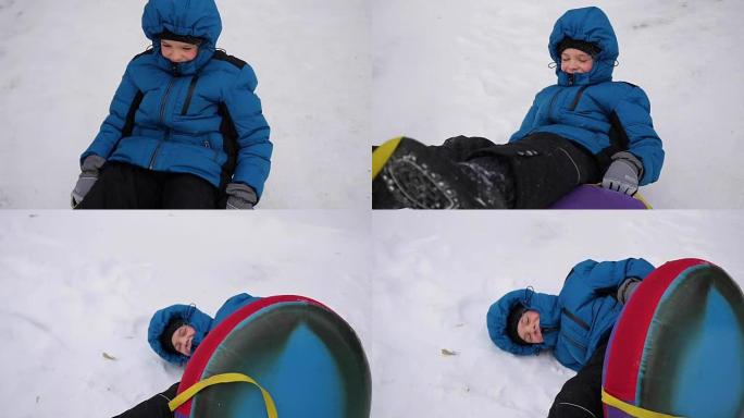 一个快乐的孩子骑在雪山上的雪管中摔倒