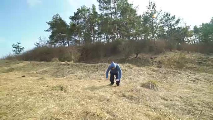 年轻的特技人员在大自然中展示跑酷的艰难技巧。慢慢地