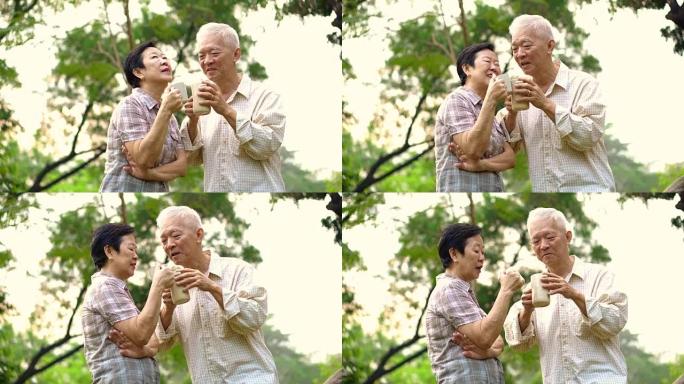 亚洲老年夫妇在早晨明亮的自然公园里通过一杯咖啡表现出深情和关怀