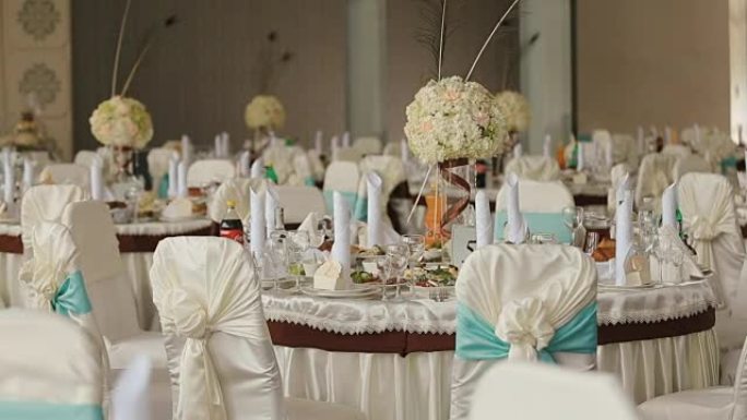 为庆祝而准备的装饰好的婚礼大厅。宴会桌，摆满了各种餐点，并为活动做好了准备
