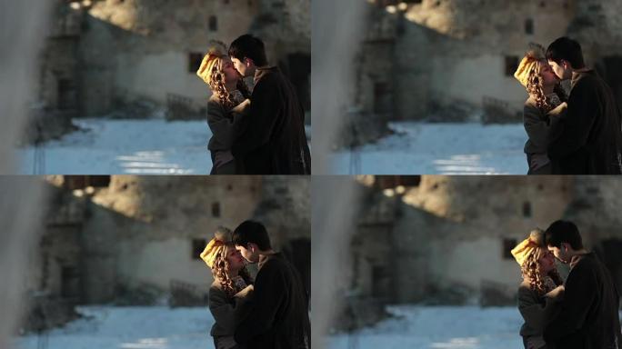 穿着传统服装的浪漫情侣在古老的中世纪城堡轻吻
